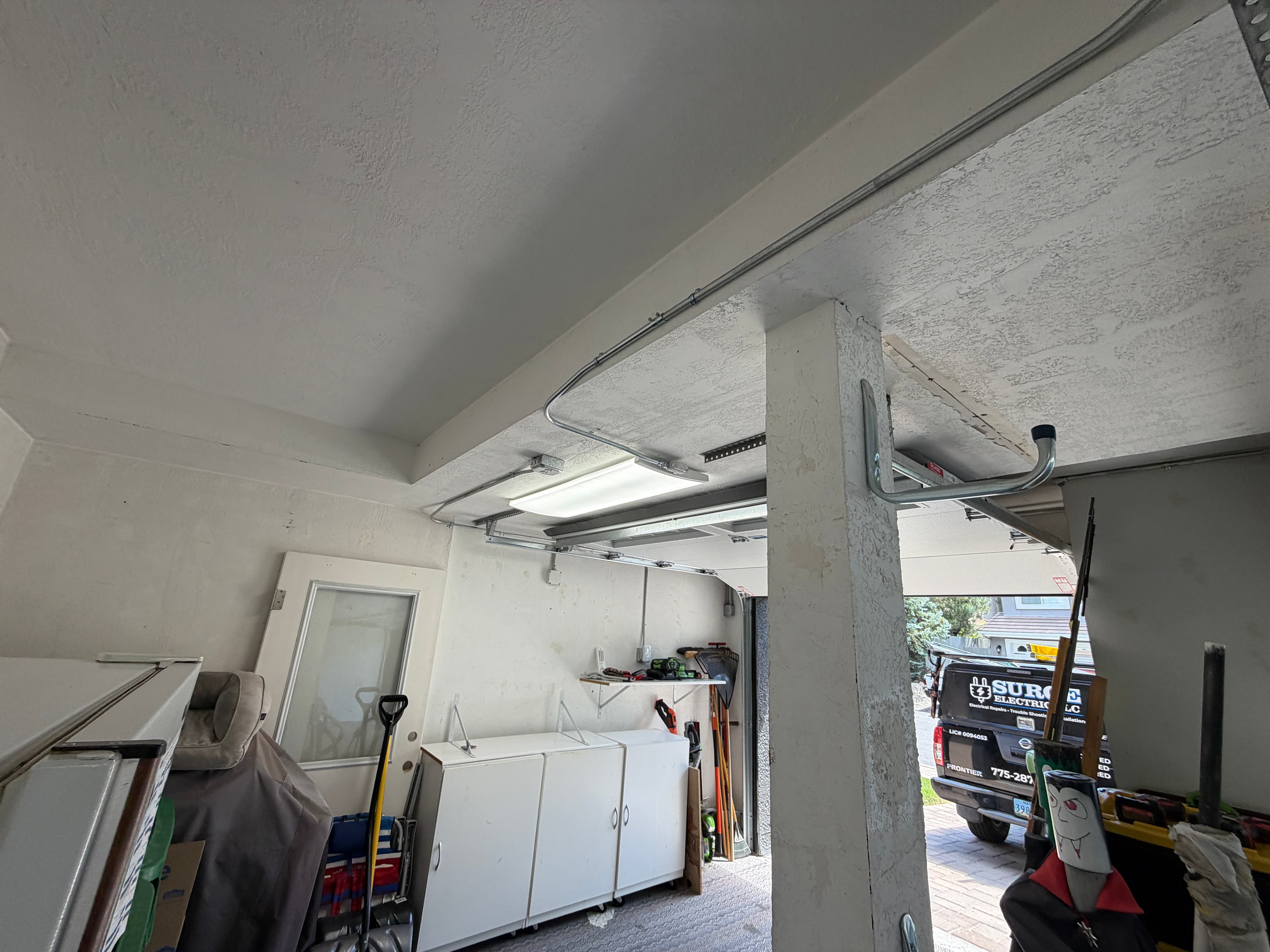 Before and after garage lighting upgrade with wall-switch control and surface-mounted conduit in Reno, Nevada
