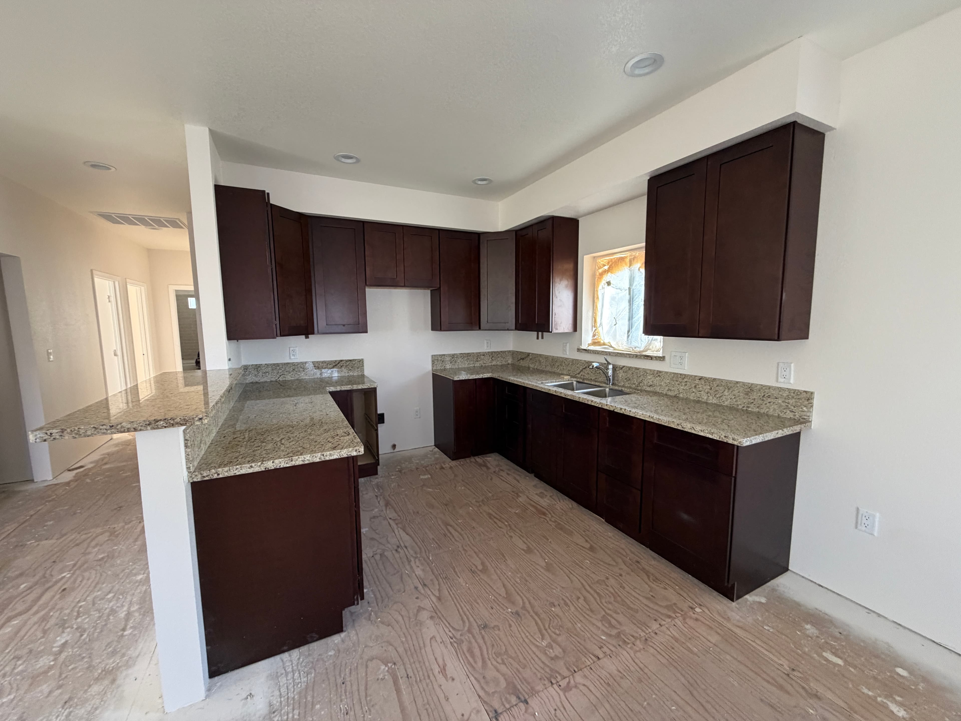 Whole-home new construction electrical installation in Reno with completed kitchen, interior lighting, receptacles, electrical panel, and overhead service