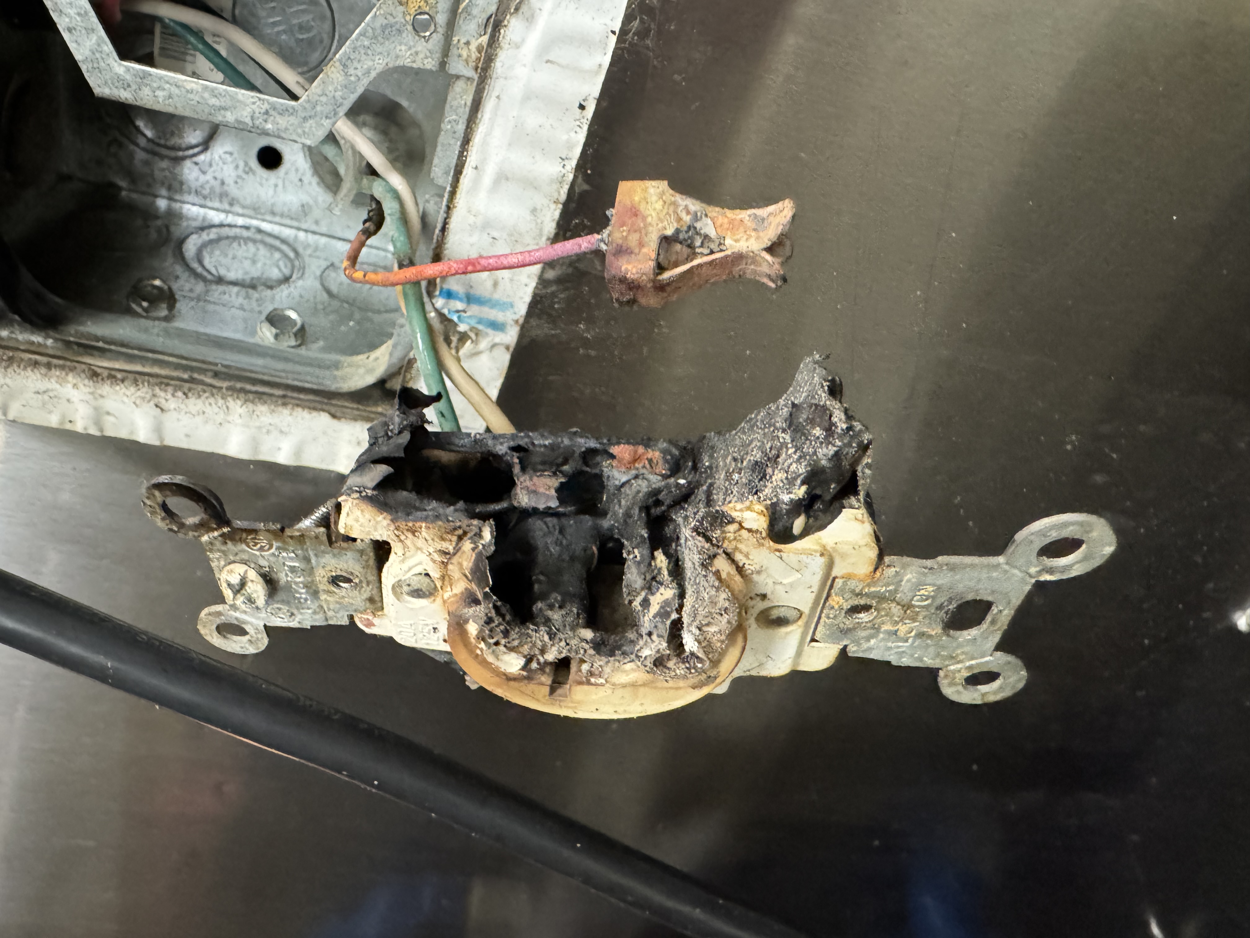 Burned electrical outlet removed during diagnostic troubleshooting by Surge Electric